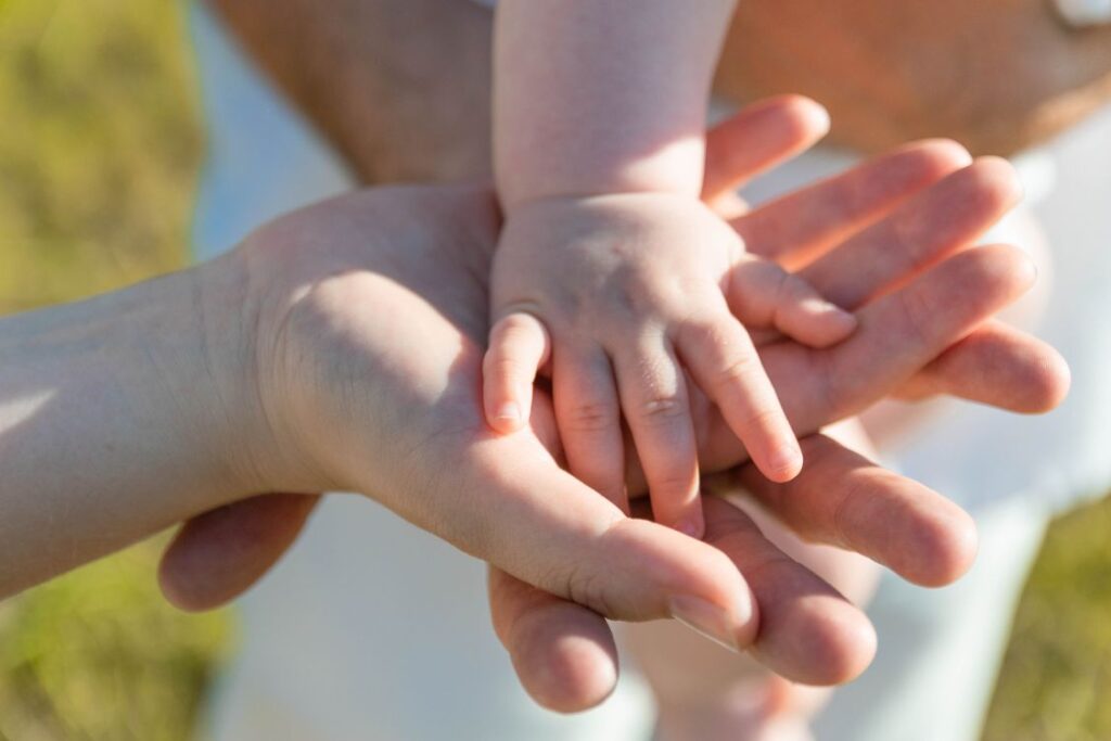 Parents holding baby's hand