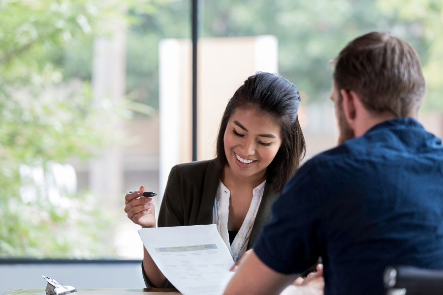 Female broker reviews loan application with male client