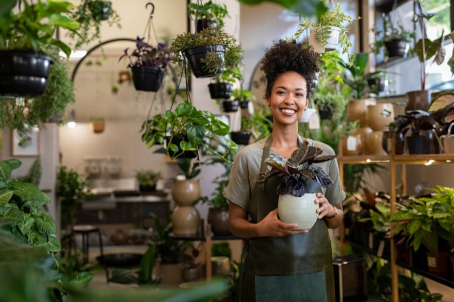 Portrait photo of young botanist smiling and wearing a green apron