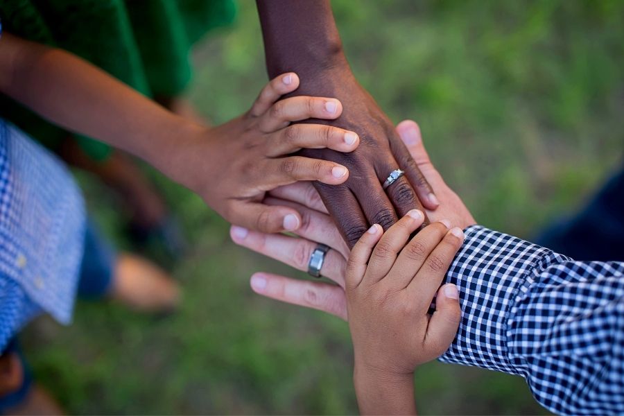 Interracial family hands holding two children