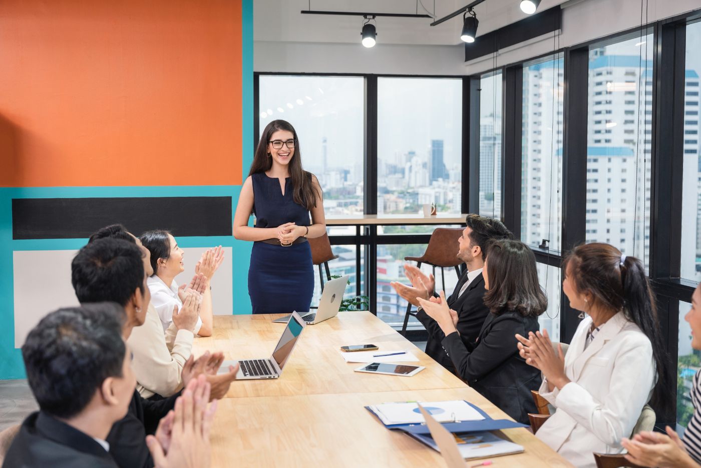 Group of people cheering and applauding successful colleague