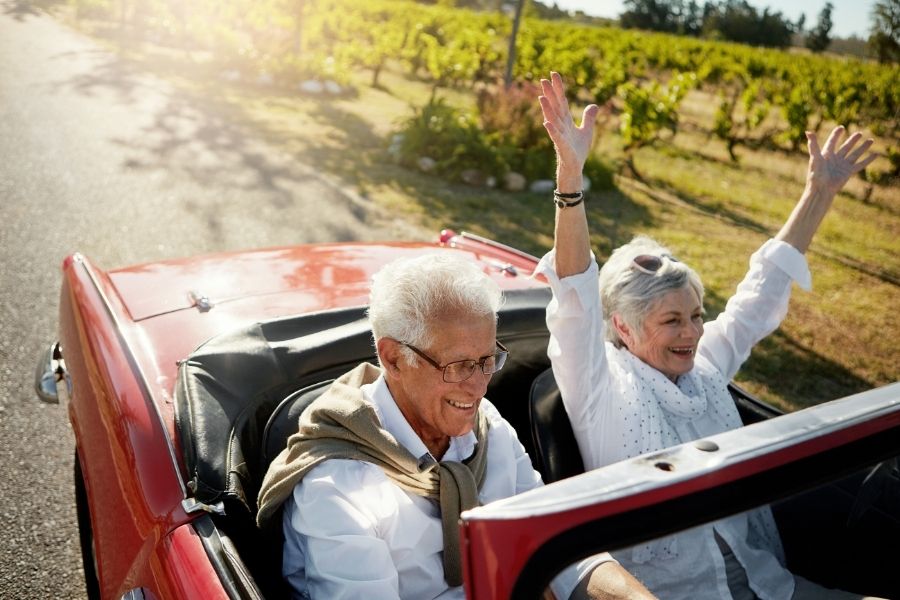 Two elder couples enjoying retirement in a car