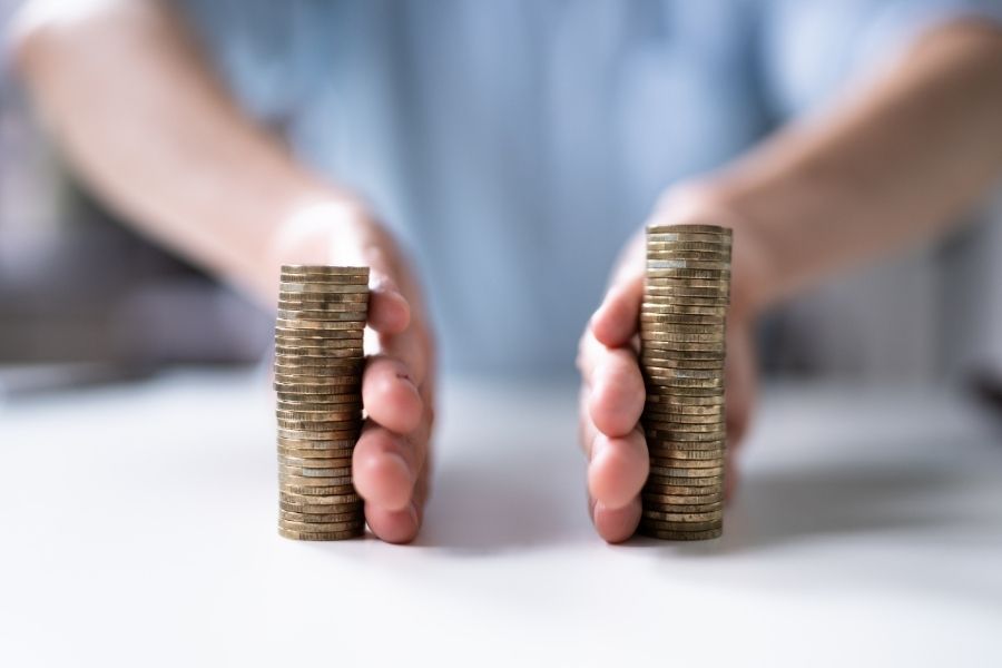 Two different arms separating a coin stack with a man at the back