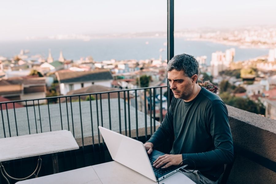 Man working remotely with a background of the beach