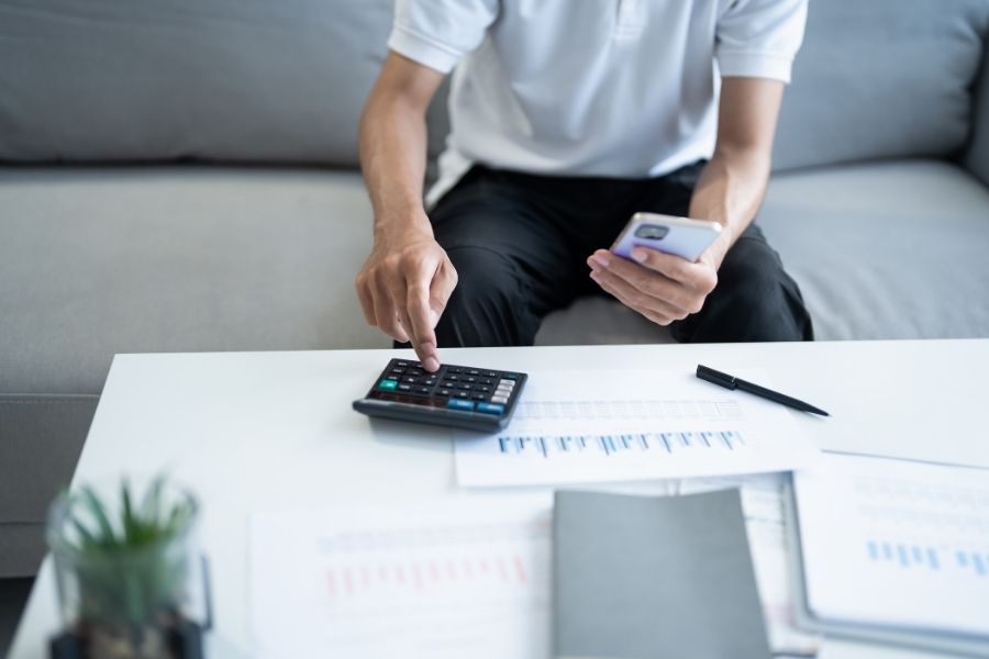 Man calculate finances home pay bills taxes on mobile phone