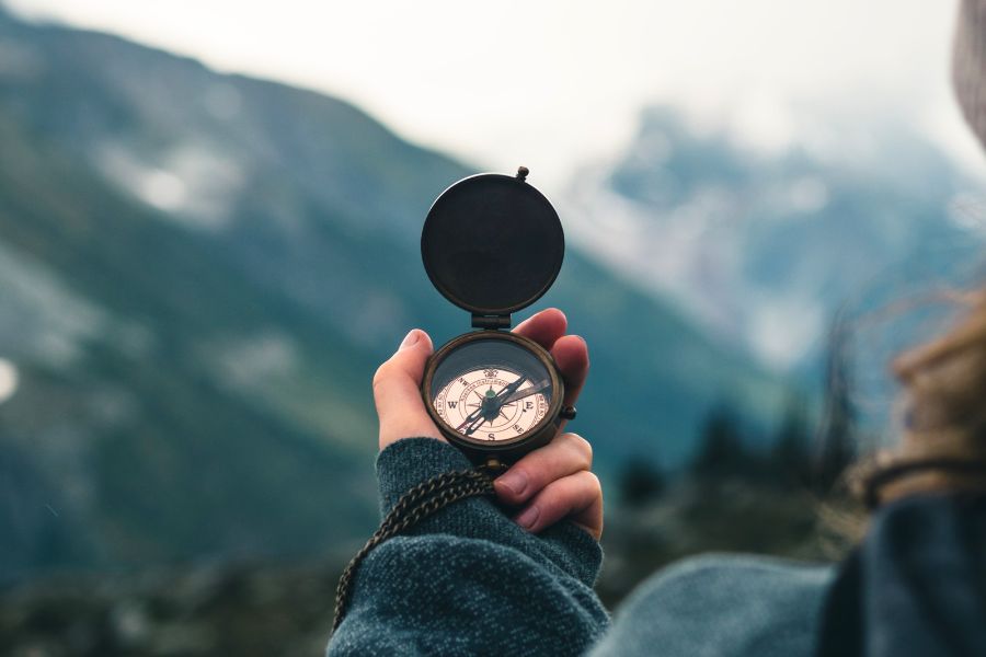 a person holding a compass A person wearing black jacket holding a compass