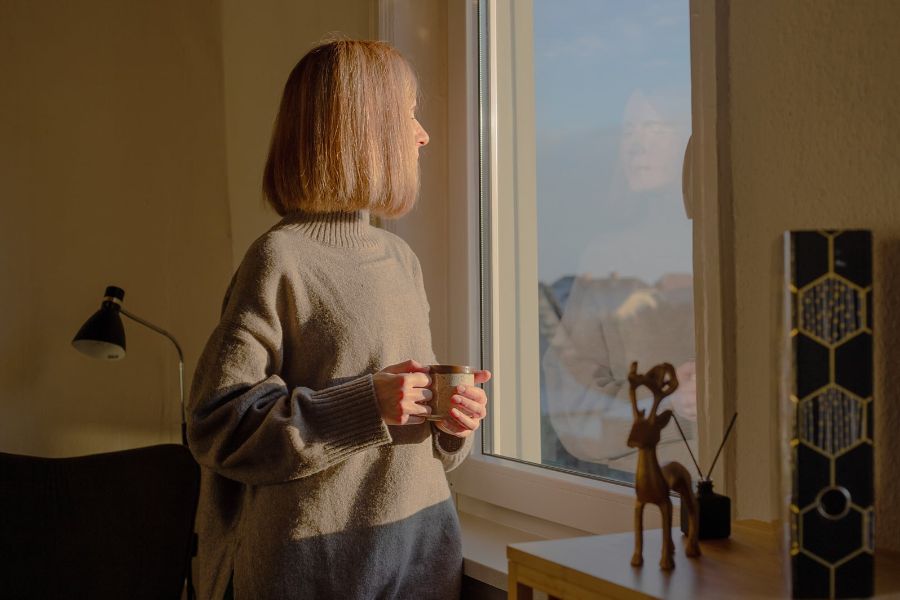 Woman looks thoughtful in window